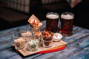 snacks to beer in glass glasses on a wooden table