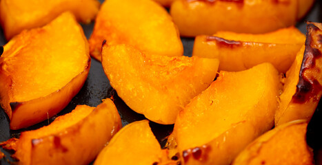 Pieces of pumpkin baked on a baking sheet. Food