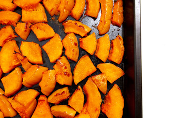 Pieces of pumpkin baked on a baking sheet