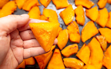 Oven baked pumpkin in a man's hand.