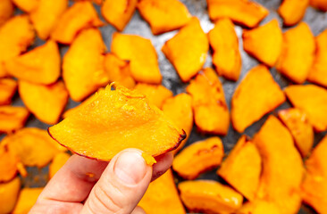 Oven baked pumpkin in a man's hand.