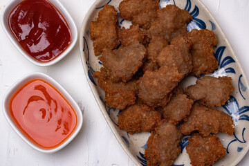 Fried Pork Cake with Ketchup and Chili Sauce on a white table top view. Asia Travel Cuisine concept.