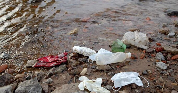 Hand collects plastic waste on the shore. These are Refined Petroleum Products (polystyrene, polyethylene, PET, polypropylene, styrofoam).