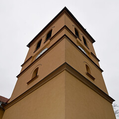 The belfry erected at the beginning of the 20th century and the close-up of the windows and the cross of the Catholic church of of Saint Anthony of Padua in the town of Gąski in Masuria in Poland © Jacek Sakowicz