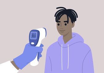 Covid-19 prevention, a hand holding a Medical Infrared Thermometer, a young male Black patient being checked for a body temperature