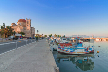 Fototapeta premium Port of charming Aegina town with yachts and fishermen boats docked in Aegina island, Saronic gulf, Greece, at sunset.