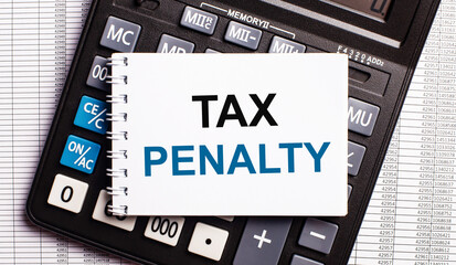On the table are reports, a calculator and a card with the words TAX PENALTY on it. Business concept