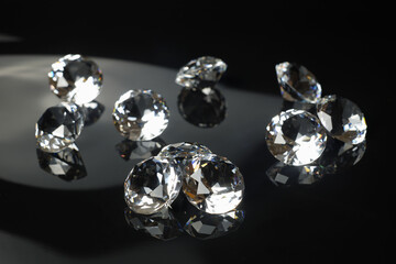 Several excellent pure diamonds with reflection on black mirror background close up view selective...