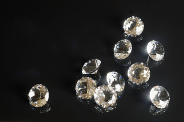 Several excellent pure diamonds with reflection on black mirror background close up view. Jewelry...