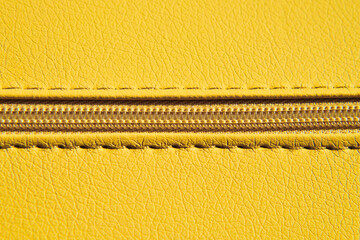 Close-up of yellow zipper on leather or leatherette material. Clothes and accessories background. © Олег Арюткин