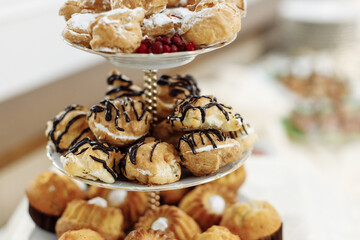 Snack for a banquet or buffet. Fresh pastries from cupcakes and croissants, confectionery on a platter, a holiday.