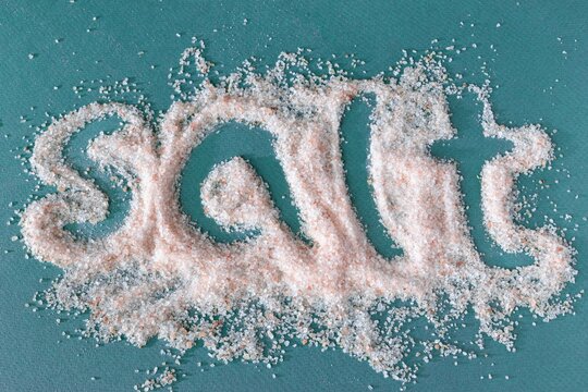 The inscription is made of pink Himalayan salt on a dark turquoise background. Cooking.