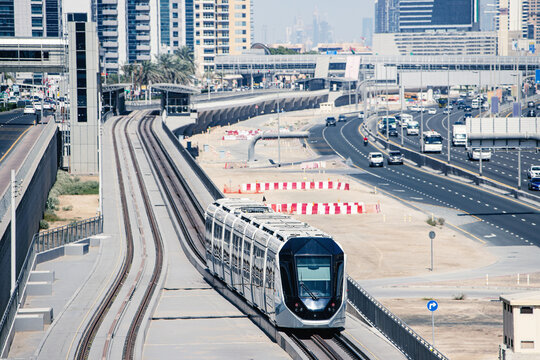Hightech modern automated tram rides on the Sheikh Zayed Highway in Dubai, aerial view. Concept of public transport and railway interchanges