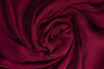 Soft smooth burgundy silk fabric background. Fabric texture.