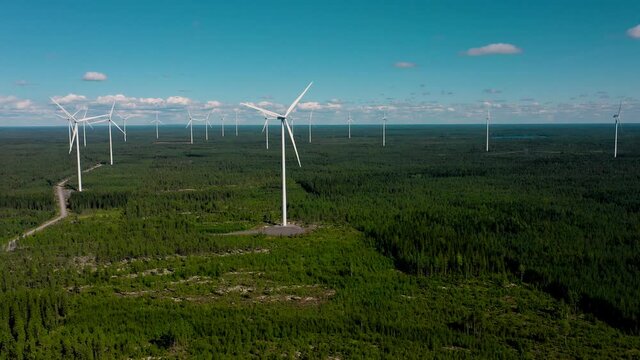 Aerial view of wind farm mills, summer in Scandinavia - tracking, drone shot