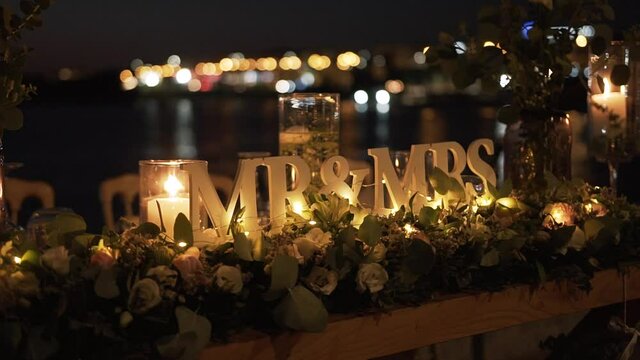 Mr and Mrs decoration at dinner night  wedding party with candle burning, flowers and sea
