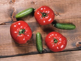 Fresh and juicy tomatoes and cucumbers on a wooden tabletop