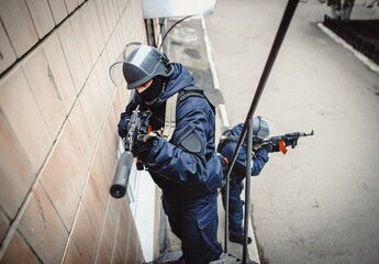 Police on task. A police officer with a weapon storming the house. Special Forces