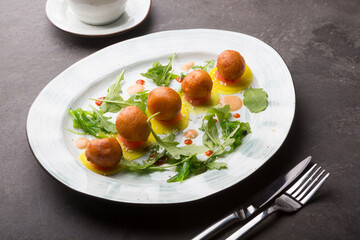 Asian donuts served with arugula and sauce on a dark table