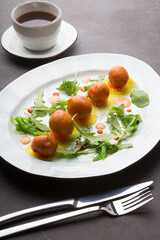 Asian donuts served with arugula and sauce on a dark table