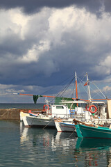 Fishing port of Naousa, Paros island, Greece, during a cloudy day with dark clouds that indicate that a storm is probably coming.