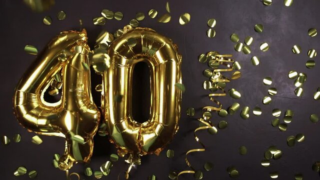 golden foil balloon number forty. Birthday or anniversary card with the inscription 40. Black concrete background. Anniversary celebration. copy space