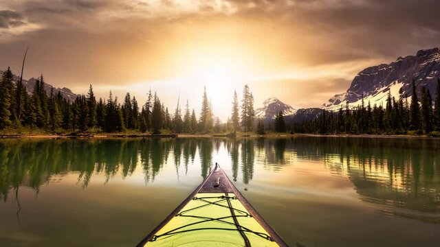 Cinemagraph Seamless Continuous Loop Animation. Kayaking in a glacier lake during a vibrant sunny summer morning. Sunrise Sky Art Render. Taken in Bow Lake, Banff National Park, Alberta, Canada.