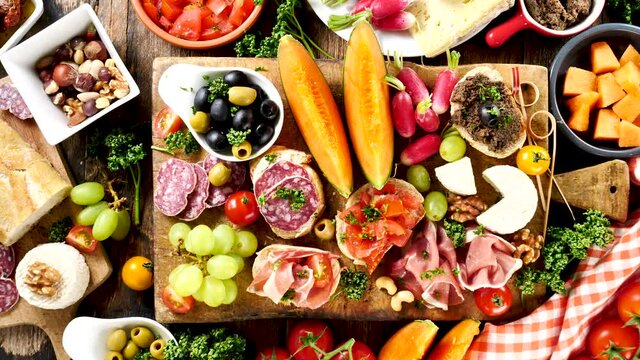 Antipasto platter with ham, prosciutto, salami, cheese, crackers and olives