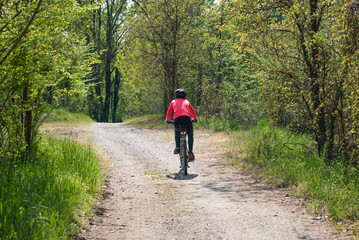 ciclista pedala nel parco sud del fiume adda