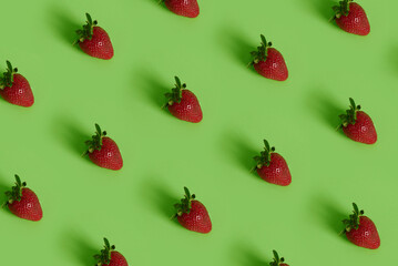 Colorful pattern of strawberries on green background with copy space