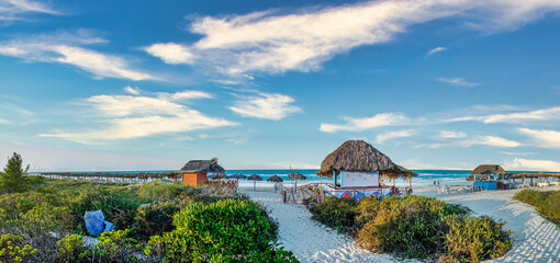 Panoramic view of tropical beach resort by the sea with huts, bars and shading areas in Cayo Santa...