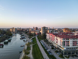 aerial view drone shot of apartments cityscape Pancevo Serbia, Tamis river at sunset.