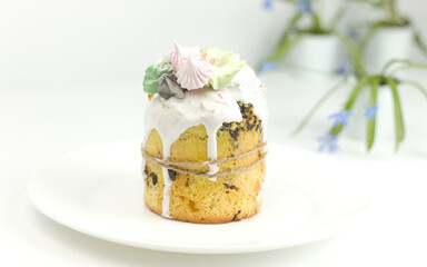 Orthodox Easter cake with white fondant and marshmallows tied with a rope on a plate with spring...