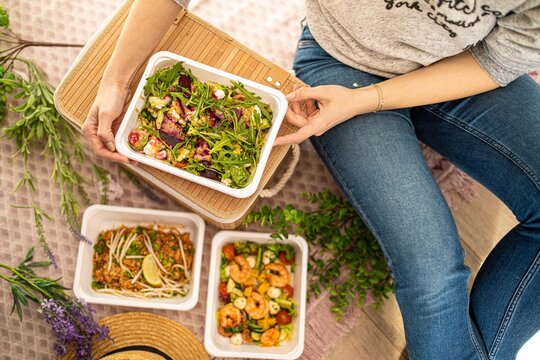 Girl Hands Are Holding Plastic Container Salad With Rucola Beetroot And Feta Cheese. Food Delivery Concept. Unrecognizable People