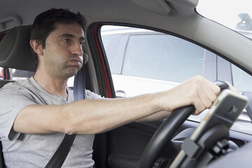 Stressed man huffing and puffing while driving. Reckless driver losing patience in traffic jam
