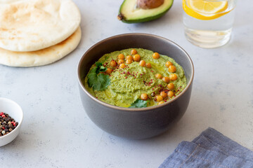 Avocado hummus in a gray bowl. Healthy eating. Vegetarian food.