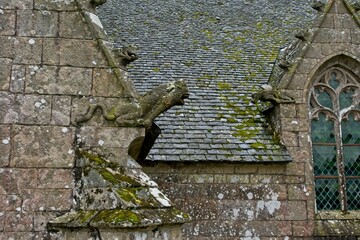 Two gargoyles worn by the elements at Plougonven Parish close in Bretagne France