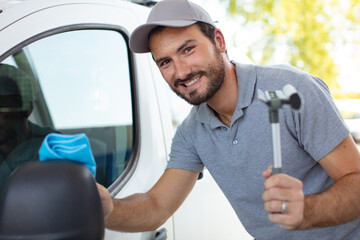 happy young man cleaning a car