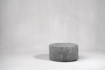 Empty round cylinder product stand on gray concrete background. Mock up. Copy space.