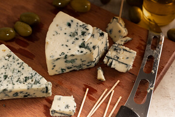 Gorgonzola cheese on a wooden board with a knife on the side