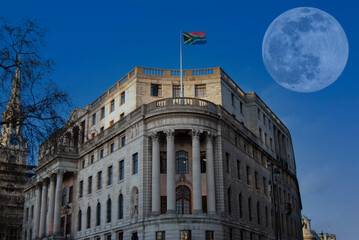 A full moon behind South Africa House overlooking Trafalgar Square in London