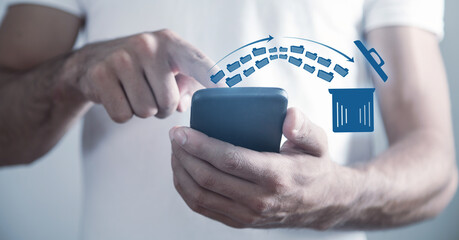 Man using smartphone. Trash can and files. Delete files