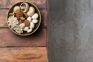 Several mushrooms in a plate on a rustic wooden table