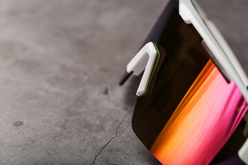 Sports glasses with a red mirrored lens and white frames on a black background