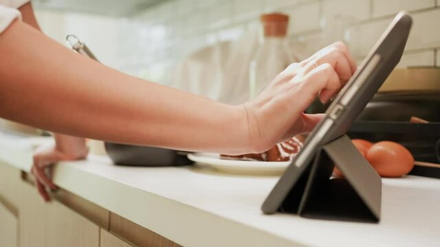 slow motion scene  woman hand touchscreen on tablet to learn about bakery receipt program  to practice from streaming website and cooking online course for healthy living concept	