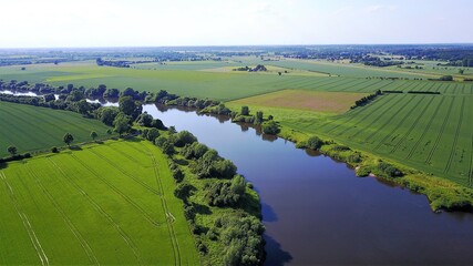 aerial view of a river and farmland with tractor lanes