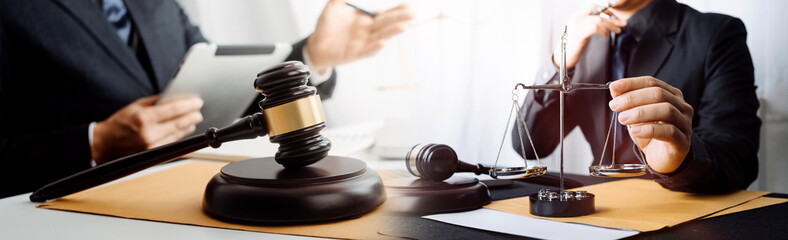 Business and lawyers discussing contract papers with brass scale on desk in office. Law, legal services, advice, justice and law concept picture with film grain effect