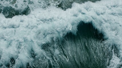 Vitality of blue energy and clear ocean water. Powerful stormy sea waves in top-down drone shot perspective.  Crashing wave line in Open Atlantic sea with foamy white texture.
