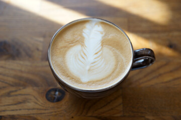 Cup of cappuccino on a wooden table in a better light