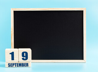September 19. Day 19 of month, Cube calendar with date, empty frame on light blue background. Place for your text. Autumn month, day of the year concept